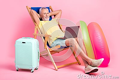 Full body photo nap sleepy senior man hands head lying sunbed comfort watching netbook business course isolated on pink Stock Photo
