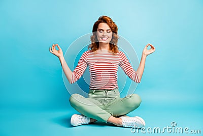 Full body photo of positive calm woman sit crossed legs meditate yoga show om symbol wear white shoes outfit isolated Stock Photo