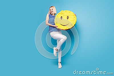 Full body photo of young girl happy positive hold paper pinata emoji smile look empty space isolated over blue color Stock Photo