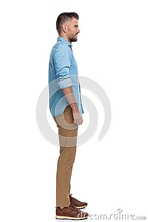 Full body picture of middle aged man in denim shirt standing in line Stock Photo