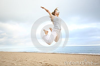 Excited happy woman jumping on the beach Stock Photo