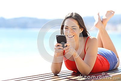 Happy woman chatting on phone on the beach Stock Photo