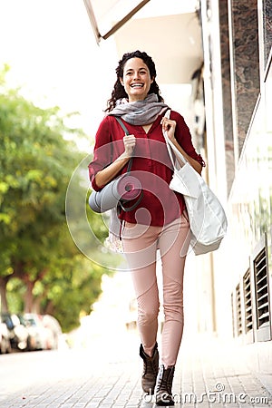 Full body happy young woman walking to yoga lesson Stock Photo