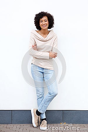 Full body smiling african american woman with arms crossed against white wall Stock Photo