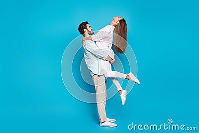 Full body profile portrait of two cheerful persons guy hold on hands lady enjoy moment isolated on blue color background Stock Photo