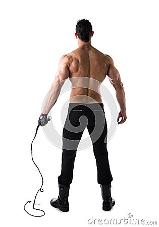 Full body shot of muscular man with whip and leather glove, seen from the back Stock Photo