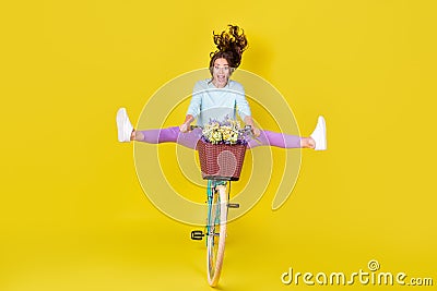 Full body size photo of insane young girl riding vintage unusual bike flying from hill carry flowers wind blow hair wear Stock Photo