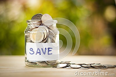 Full coins in a jar. Saving money concept and save money to support everything in life with sun light bokeh background Stock Photo