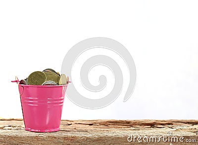 Full coins in pink bucket. Stock Photo