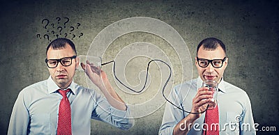 Full of doubts business man with qirstions listening to self inner voice Stock Photo