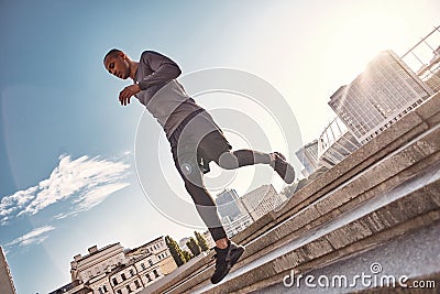 Full of energy Full length portrait of athletic african man running on stairs with very fast speed on sunny morning Stock Photo