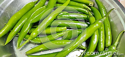 Full frame close up of a bunch of bright and shiny green chili peppers. Stock Photo