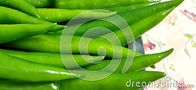 Full frame close up of a bunch of bright and shiny green chili peppers. Stock Photo