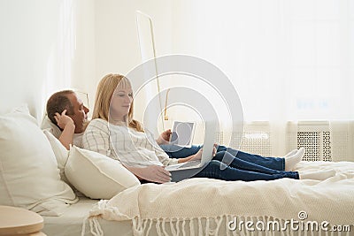 Full lenght portrait of mature couple with digital addiction at home. Stock Photo