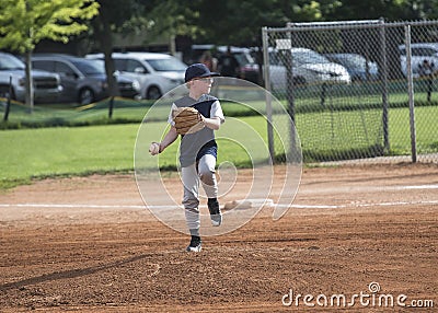 Full length Action photo of a Little League baseball pitcher throwing a pitch Stock Photo