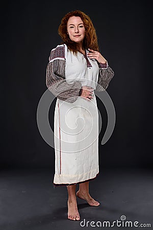 Full length of barefooted positive woman in long dress with embroidery pattern Stock Photo