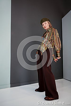 Full length Beautiful woman poses in fashionable clothes, brown wide leg trousers and leather loafer shoes, printed Stock Photo