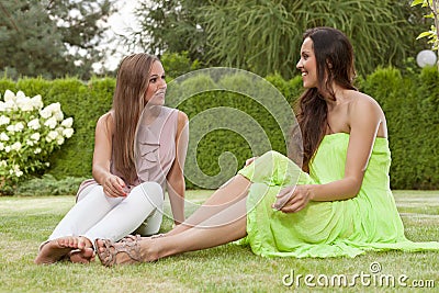 Full length of beautiful young female friends conversing in park Stock Photo