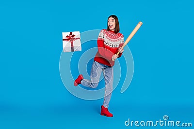 Full length body size photo amazed girl keeping wooden bat to beat christmas present isolated bright blue color Stock Photo