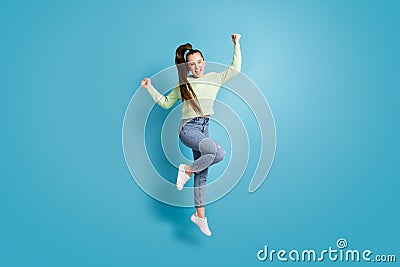 Full length body size photo of jumping girl ponytail gesturing like winner shouting isolated on vibrant blue color Stock Photo