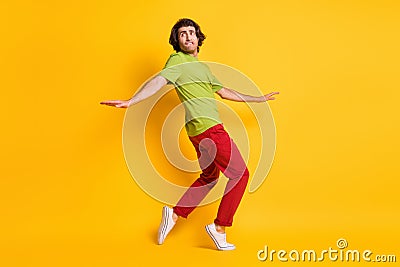 Full length body size photo of man going tiptoes looking nervous afraid fear burglar biting lip isolated on vivid yellow Stock Photo