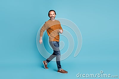 Full length body size photo middle-aged bearded man smiling going fast hurrying in casual outfit isolated on vibrant Stock Photo