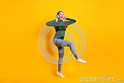Full length body size photo overjoyed girl listening music singing song dancing party isolated on vibrant yellow color Stock Photo