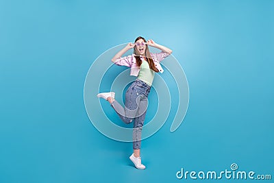 Full length body size photo overjoyed girl wearing casual clothes dancing in sunglass isolated pastel blue color Stock Photo