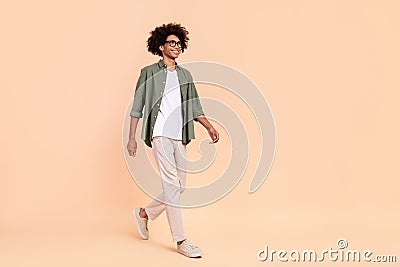 Full length body size view of attractive cheerful smart guy going isolated over beige pastel color background Stock Photo