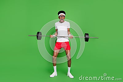 Full length body size view of trendy tired weak guy nerd sportsman lifting heavy barbell isolated over bright green Stock Photo