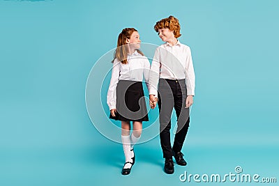 Full length body size view of two attractive cheerful kids holding hands going isolated over bright blue color Stock Photo