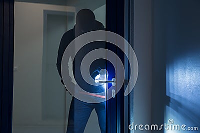 Burglar Using Crowbar To Open Glass Door Stock Photo