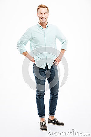 Full length of cheerful handsome young man standing and smiling Stock Photo