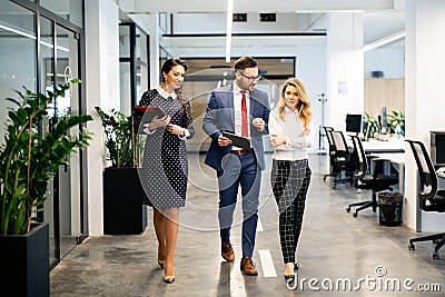 Full length of group of happy young business people walking the corridor in office together Stock Photo
