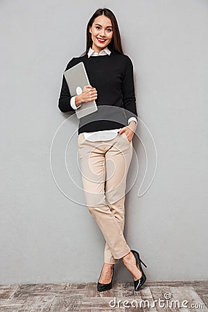 Full length image of Pleased asian woman in business clothes Stock Photo