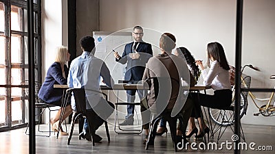 Full length male speaker presenting project to diverse colleagues. Stock Photo