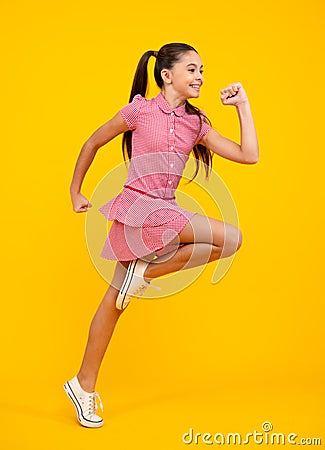 Full length overjoyed teenager kid girl 12 13 14 year jumping old isolated on blue background studio. Funny run and jump Stock Photo