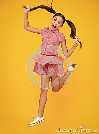 Full length overjoyed teenager kid girl 12 13 14 year jumping old isolated on yellow background studio. Funny jump Stock Photo