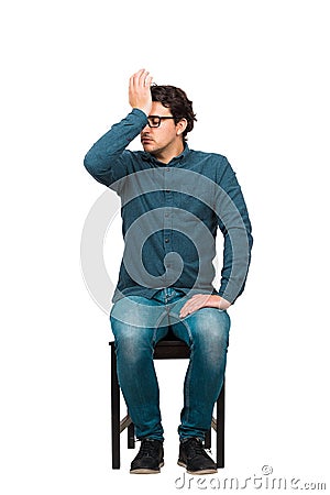 Full length of pessimistic businessman, eyes closed facepalm gesture, punching himself to forehead, seated on a chair isolated on Stock Photo