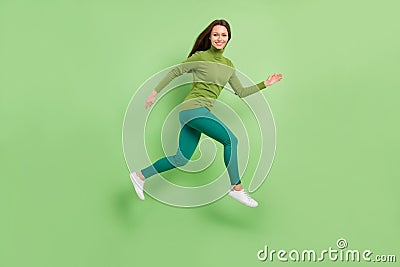 Full length photo of attractive young woman jump up good mood run sale travel dream isolated on green color background Stock Photo