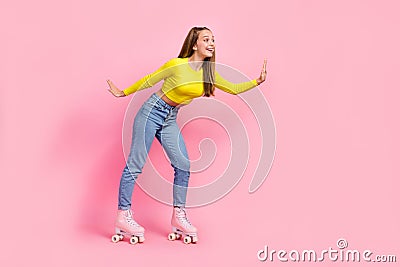 Full length photo of charming excited school girl dressed yellow crop top riding rollers empty space isolated pink color Stock Photo