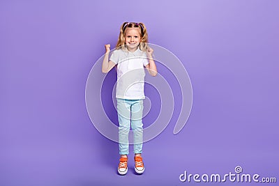 Full length photo of cute small girl tails raise fists jump win competition wear stylish white blouse isolated on violet Stock Photo