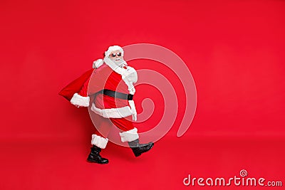 Full length photo of dreamy fat funny santa claus have eyeglasses go carry bag with presents on midnight isolated over Stock Photo