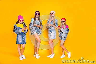 Full length photo of four nice positive cool millennials using modern technology following stars users on social network Stock Photo