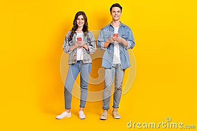 Full length photo of funky attractive best buddies wear jeans chatting twitter telegram facebook isolated yellow color Stock Photo