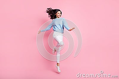 Full length photo of funny lady jump look empty space wear blue sweater isolated pink color background Stock Photo