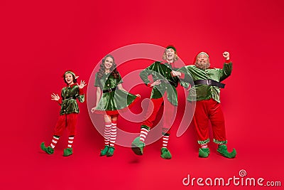 Full length photo of happy amazed santa helper enjoy holiday jolly mood spirit isolated on red color background Stock Photo