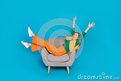 Full length photo of overjoyed carefree person sit chair have fun good mood isolated on blue color background Stock Photo