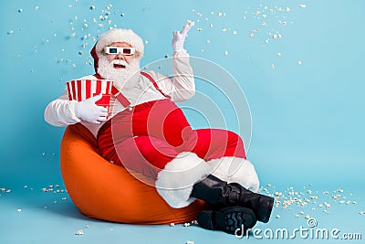 Full length photo of pensioner old man watch blockbuster throw popcorn make mess sit orange beanbag wear red santa x-mas Stock Photo