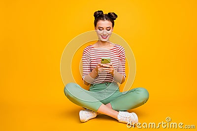 Full length photo of pretty attractive lady sit floor legs crossed hold telephone typing new post blog text wear striped Stock Photo